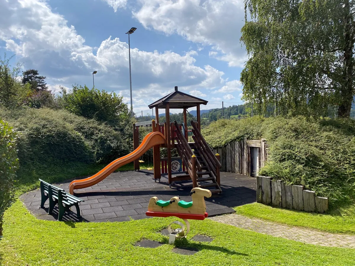 Der Spielplatz mit Rutsche und Holzturm direkt neben der Terrasse des Clubhauses