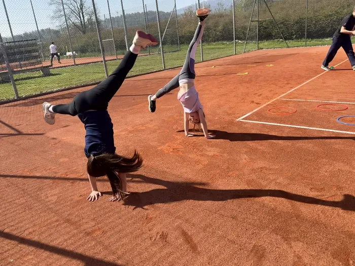 Ein Kind schlägt auf dem Sandplatz ein Rad